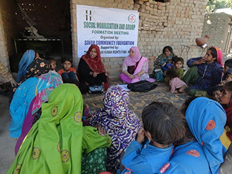 Photo of social mobilization meeting with women cotton pickers.