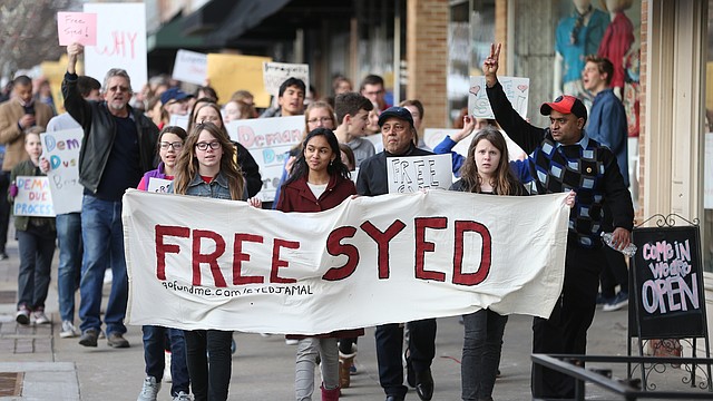 Photo of Naheen Jamal, 12-year-old daughter of Syed Jamal, center, flanked by her friends Elizabeth Anderson, left, and Anna Anderson as they lead a Free Syed Jamal march on Thursday, Feb. 8, 2018 at Lawrence Creates.
