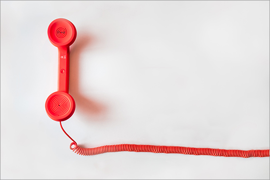 Image of red telephone receiver and cord.