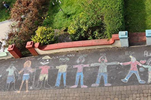 Image of chalk art on street in front of house.
