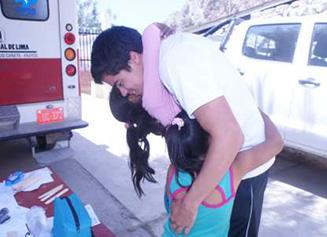 Photo of Ricardo Lewis, Nutre Perú volunteer, hugging Misleny and Daylin children from Catahuasi.