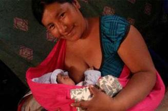 Photo of a mother breastfeeding her child using a portawawa (porta = carry, wawa=quechua word for baby) adapted by the volunteering Nutre Peru, in order to improve the rate of exclusive breastfeeding.