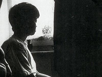 Photo of woman staring out of a window.