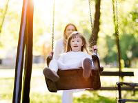 Disabled girl on a swing in a park.